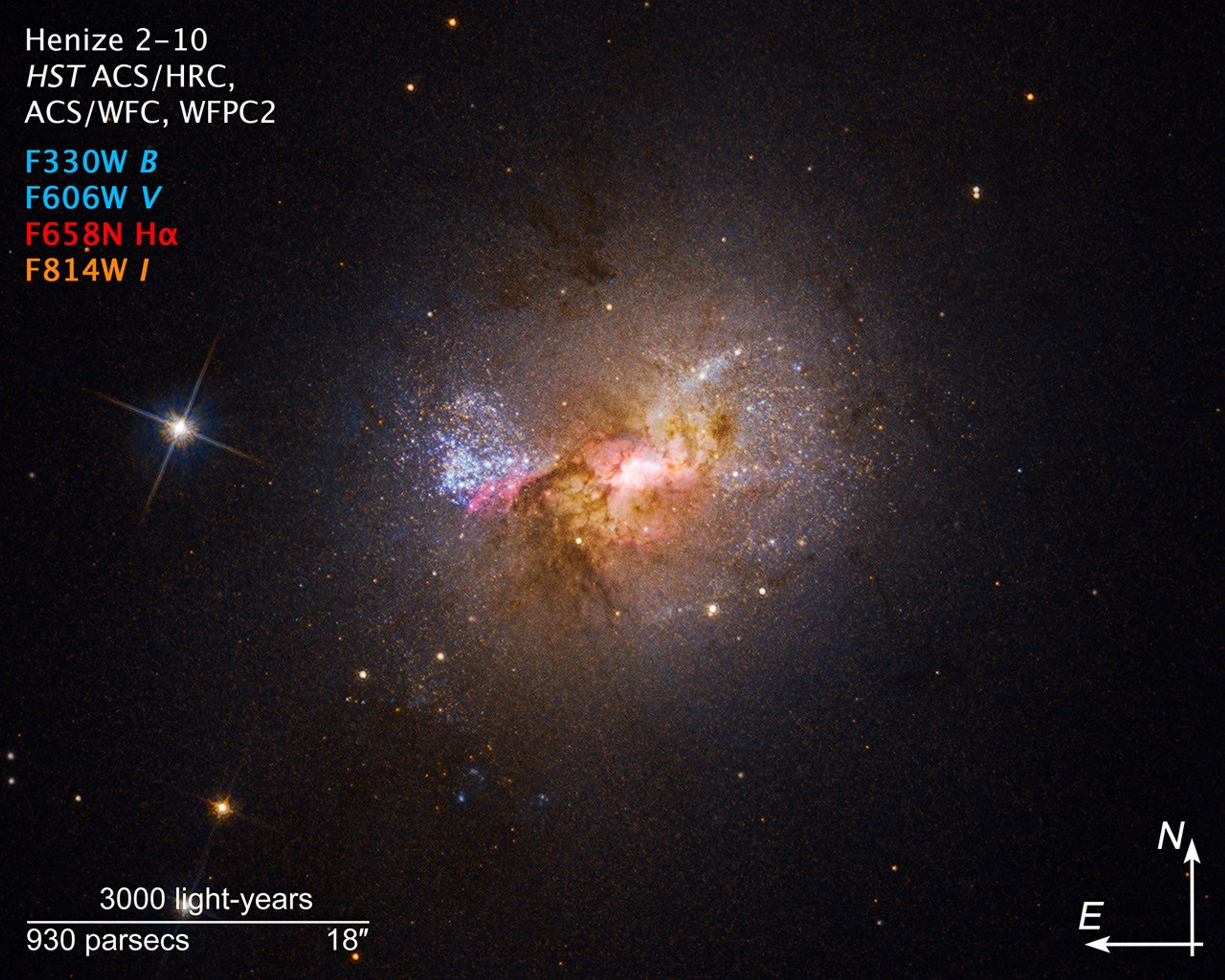 Small, bright, galaxy with star-forming regions illuminated in magenta and compass information